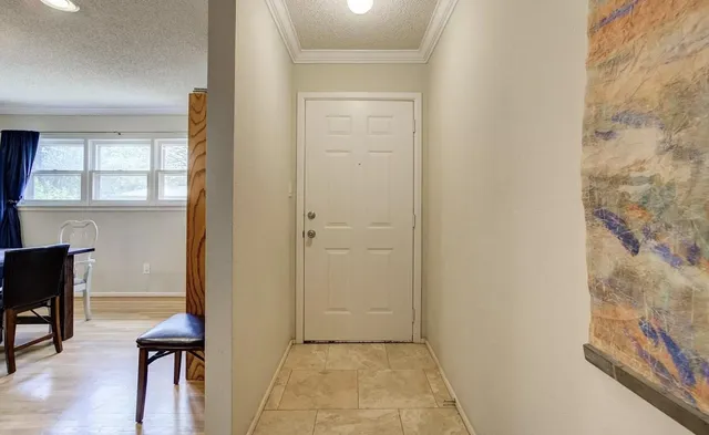a view of a hallway with furniture and a window