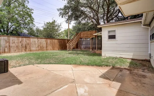 a view of backyard with small cabin and wooden fence
