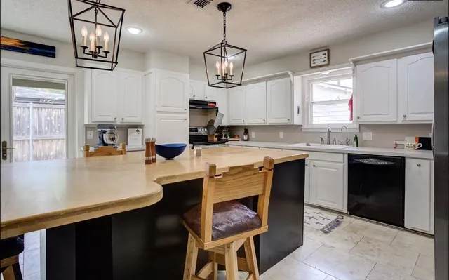 a kitchen with a center island appliances and cabinets