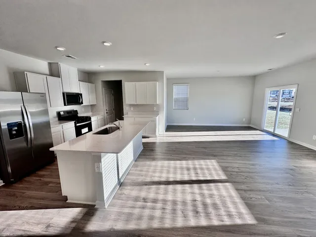a large white kitchen with stainless steel appliances
