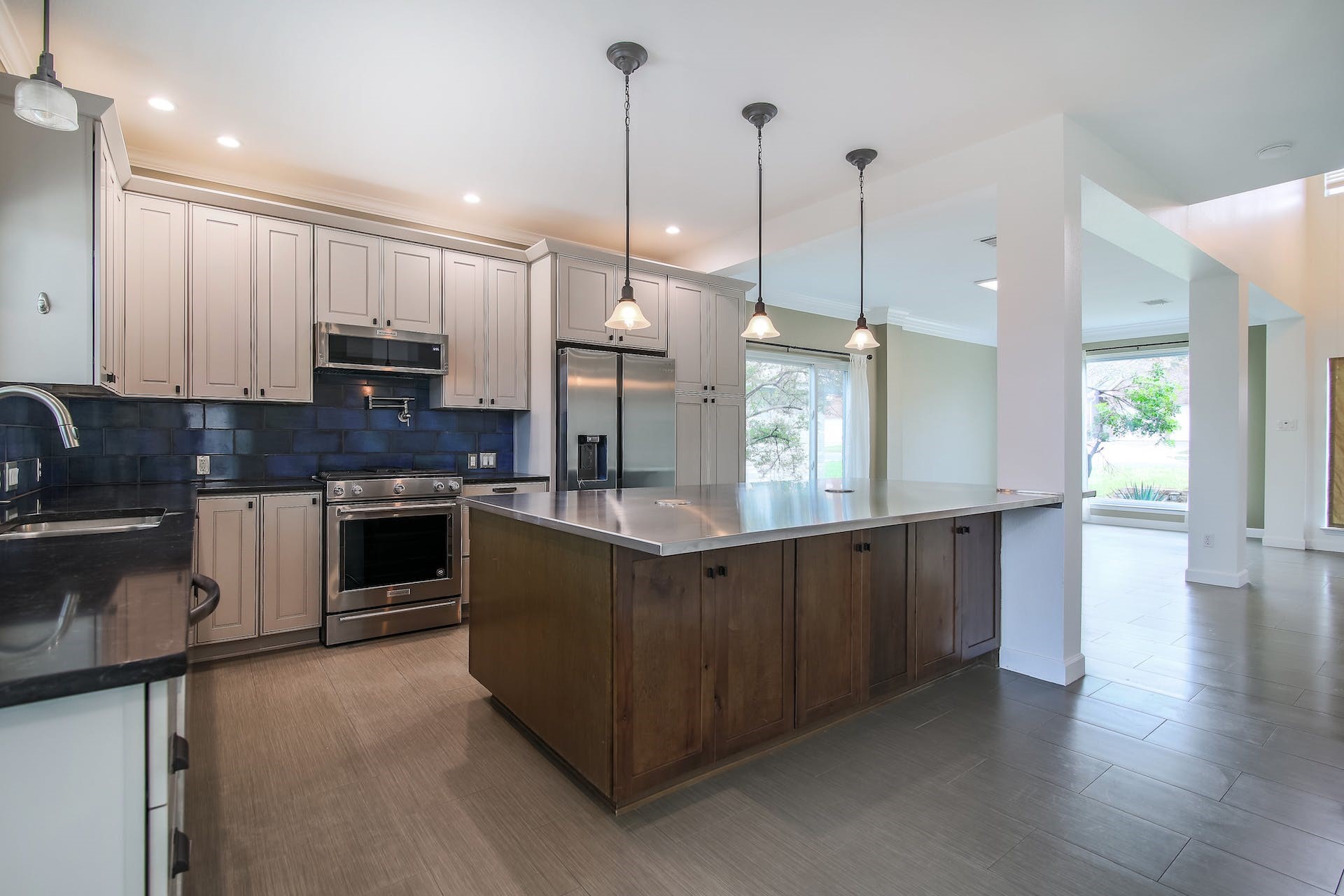 1713 Apache Trail Round Rock, TX 78665 - Photo 8 of 39 a kitchen with stainless steel appliances granite countertop a stove a sink a refrigerator a center island a stove and a wooden floor