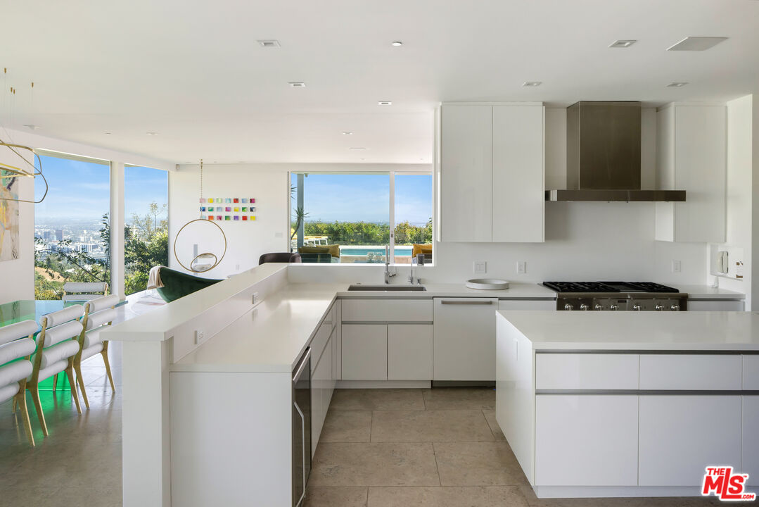 1476 Carla Ridge Beverly Hills, CA 90210 - Photo 16 of 27 a kitchen with a stove a sink and a refrigerator