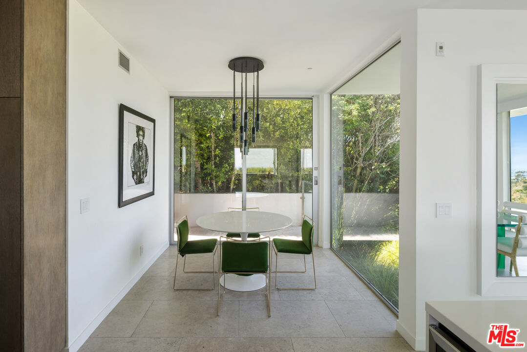 1476 Carla Ridge Beverly Hills, CA 90210 - Photo 17 of 27 a dining room with a large window and table