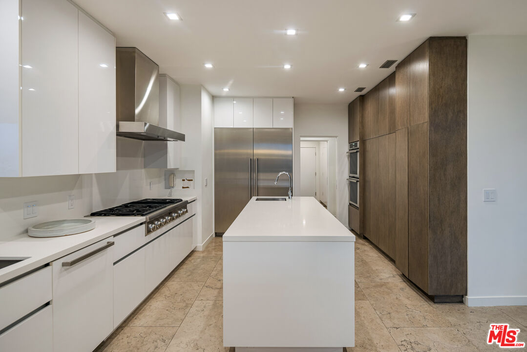 1476 Carla Ridge Beverly Hills, CA 90210 - Photo 18 of 27 a kitchen with stainless steel appliances granite countertop a refrigerator a stove and a sink