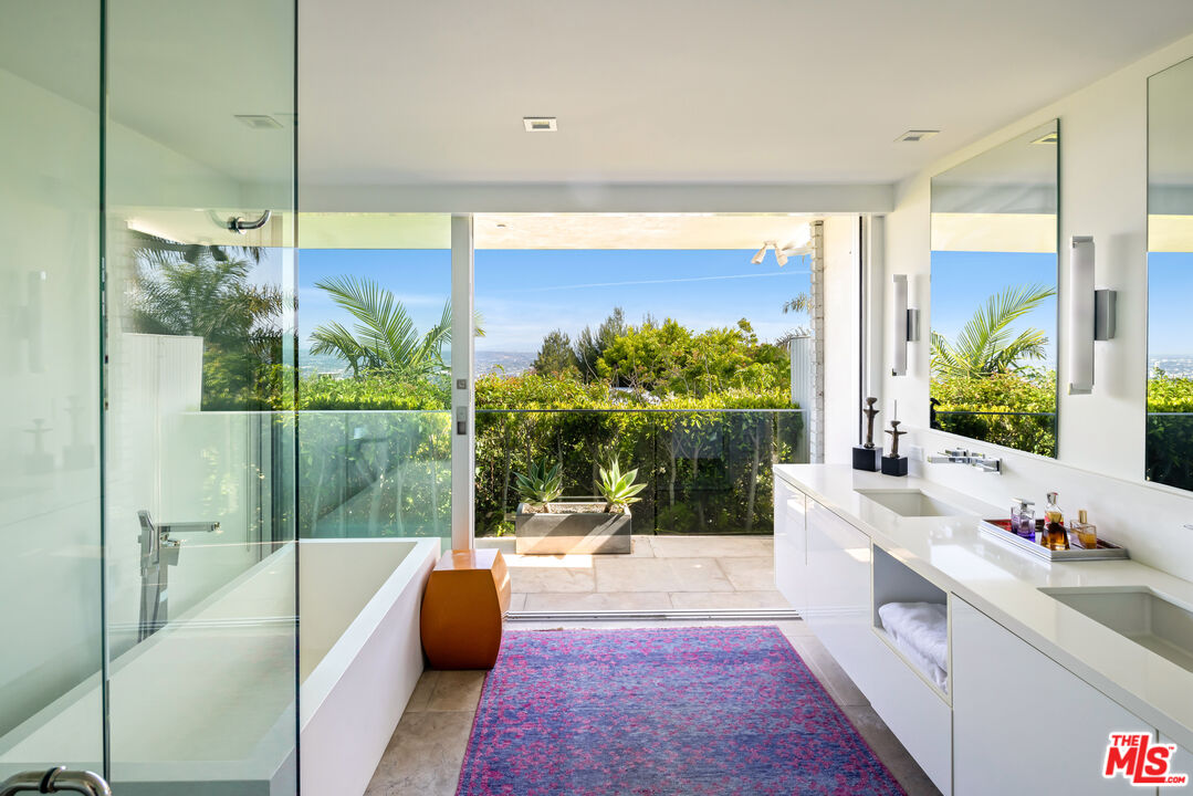 1476 Carla Ridge Beverly Hills, CA 90210 - Photo 23 of 27 a bathroom with a tub sink and mirror