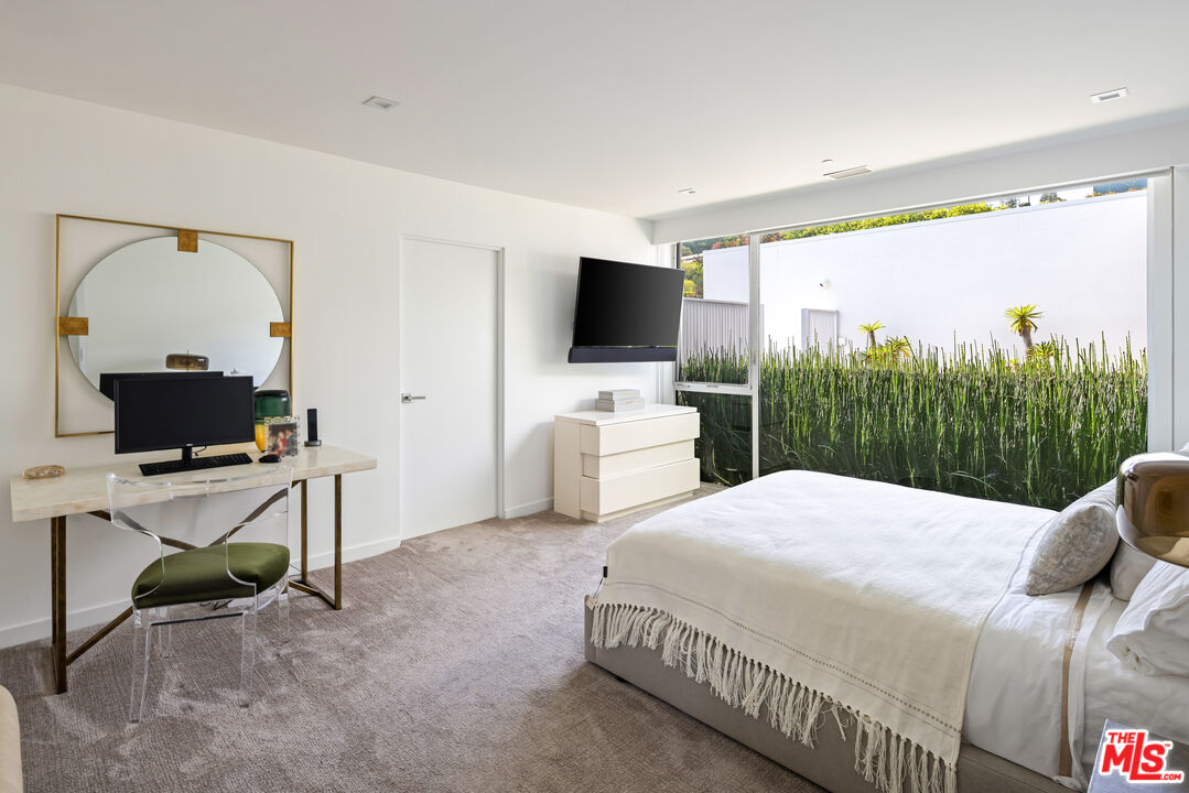 1476 Carla Ridge Beverly Hills, CA 90210 - Photo 24 of 27 a bedroom with a bed and a flat screen tv