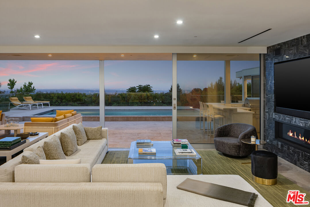 1476 Carla Ridge Beverly Hills, CA 90210 - Photo 3 of 27 a living room with furniture and a flat screen tv