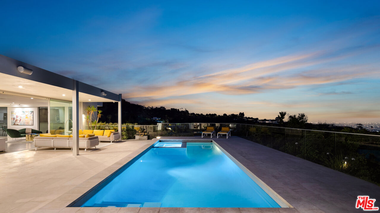 1476 Carla Ridge Beverly Hills, CA 90210 - Photo 5 of 27 a view of a swimming pool with a lounge chair and a floor to ceiling window