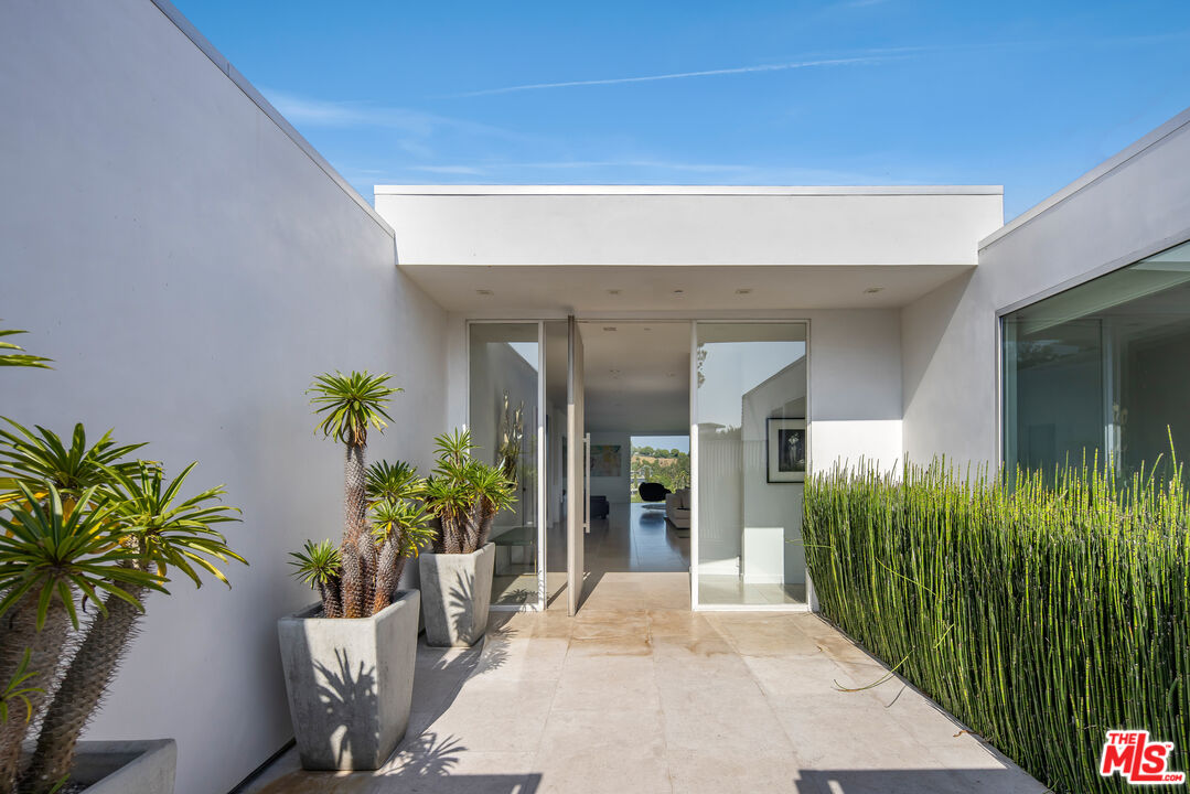 1476 Carla Ridge Beverly Hills, CA 90210 - Photo 9 of 27 a view of a entryway door with potted plants