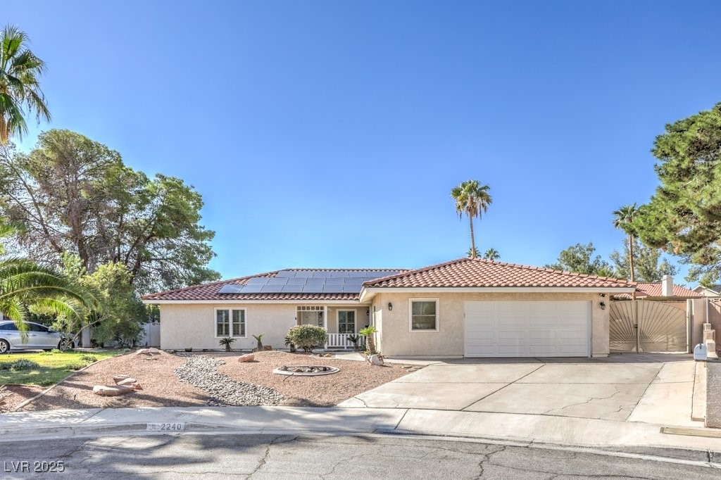 2240 Grayson Circle Henderson, NV 89014 - Photo 1 of 38 View of front of house with a gate, stucco siding, concrete driveway, roof mounted solar panels, and a garage