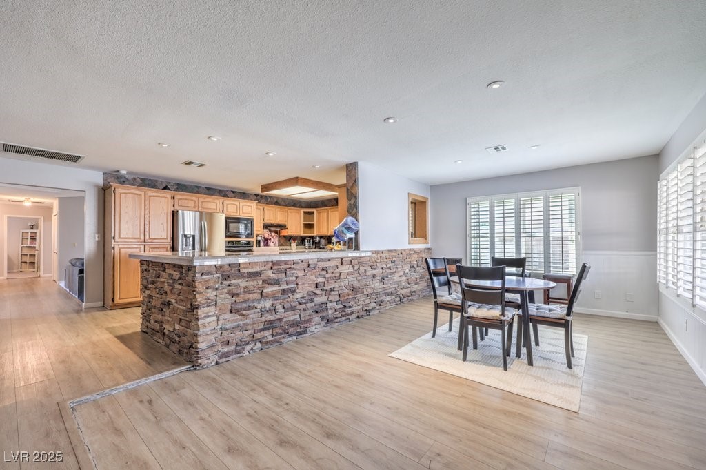 2240 Grayson Circle Henderson, NV 89014 - Photo 13 of 38 Dining space featuring light wood finished floors, a textured ceiling, and recessed lighting
