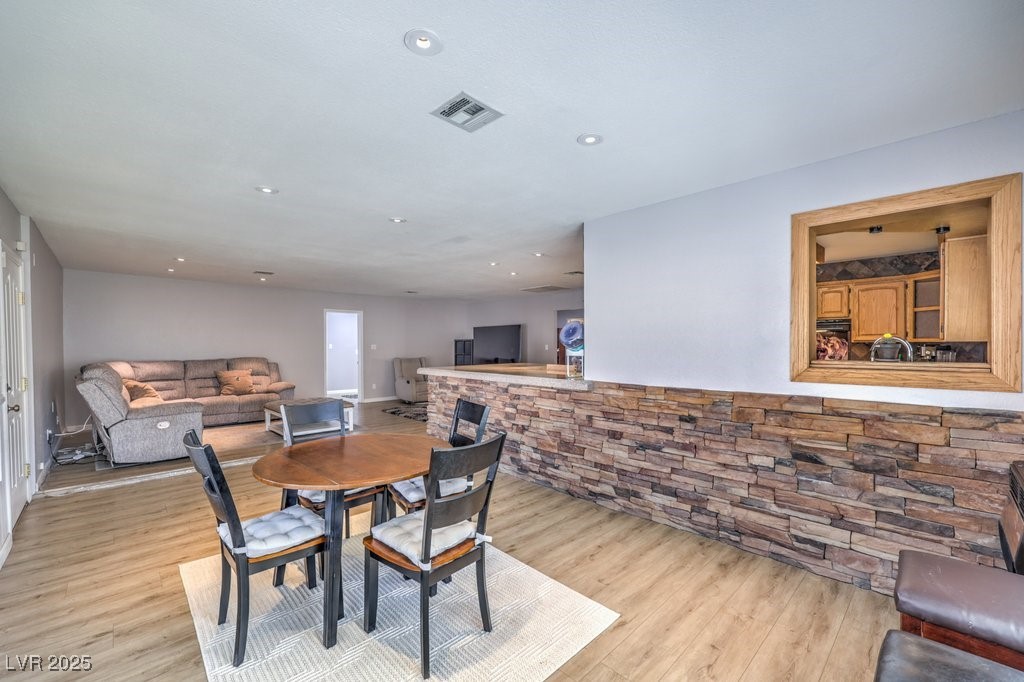 2240 Grayson Circle Henderson, NV 89014 - Photo 14 of 38 Dining area featuring recessed lighting, light wood finished floors, and a fireplace