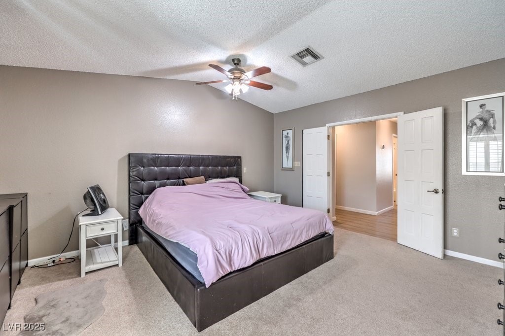 2240 Grayson Circle Henderson, NV 89014 - Photo 19 of 38 Bedroom featuring carpet, a textured ceiling, ceiling fan, vaulted ceiling, and a textured wall