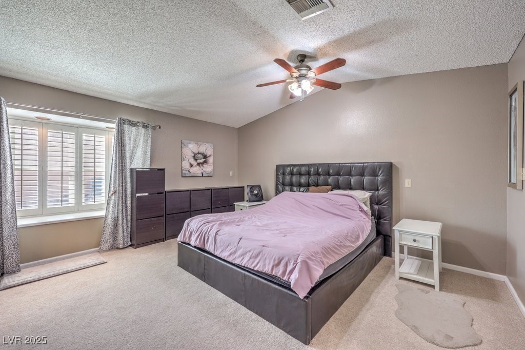 2240 Grayson Circle Henderson, NV 89014 - Photo 21 of 38 Bedroom with carpet, vaulted ceiling, a ceiling fan, and a textured ceiling