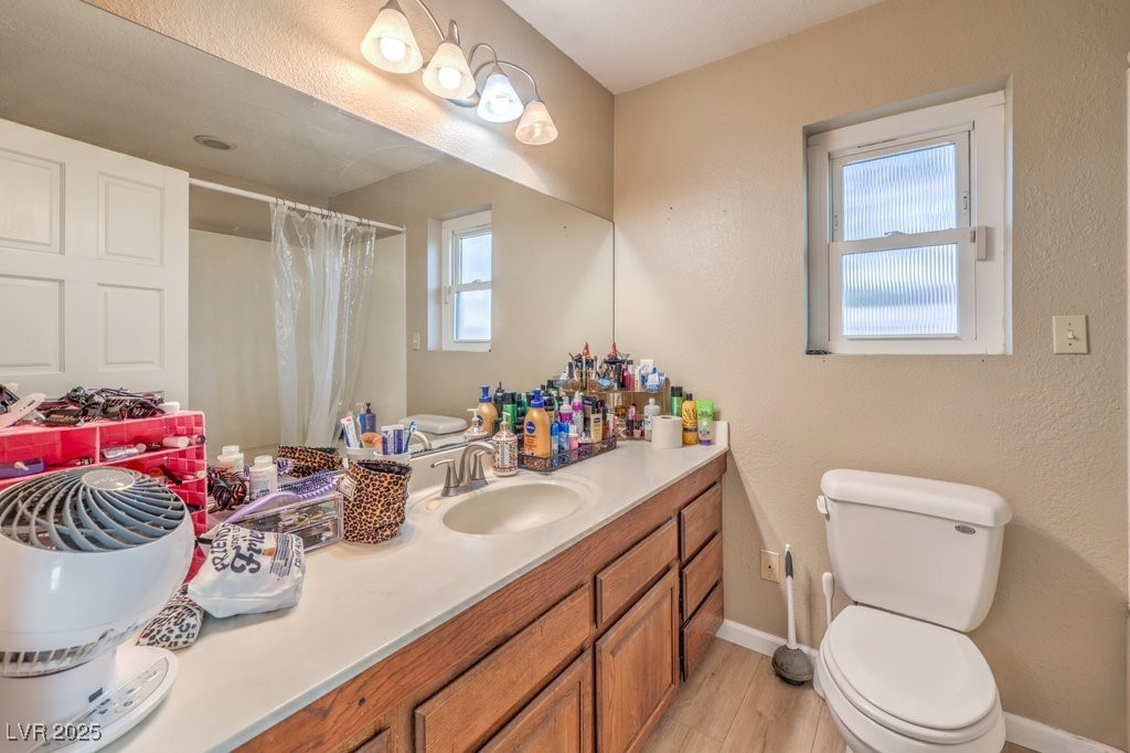 2240 Grayson Circle Henderson, NV 89014 - Photo 22 of 38 Full bath featuring vanity, a shower with curtain, light wood-style flooring, and a textured wall