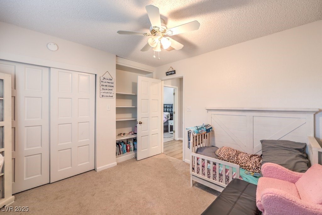 2240 Grayson Circle Henderson, NV 89014 - Photo 25 of 38 Bedroom featuring light carpet, a closet, a textured ceiling, and a ceiling fan