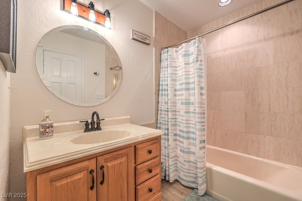 2240 Grayson Circle Henderson, NV 89014 - Photo 26 of 38 Bathroom featuring shower / bath combination with curtain, a textured wall, vanity, and light wood-style floors