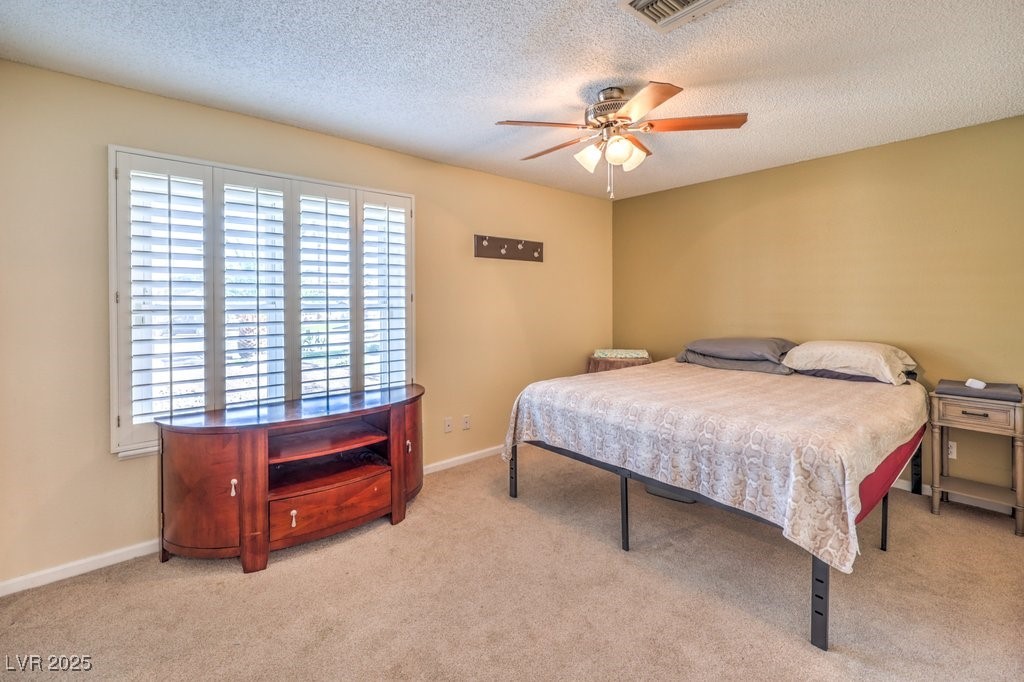 2240 Grayson Circle Henderson, NV 89014 - Photo 27 of 38 Bedroom featuring light carpet, a textured ceiling, and ceiling fan