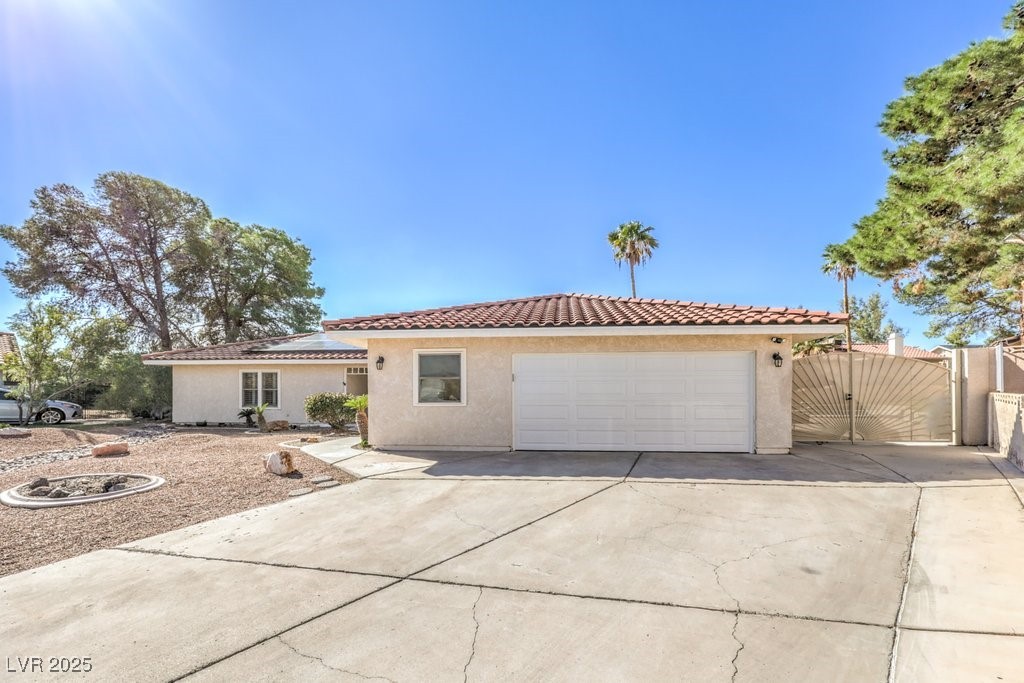 2240 Grayson Circle Henderson, NV 89014 - Photo 3 of 38 Mediterranean / spanish home featuring a tiled roof, stucco siding, a gate, a garage, and driveway