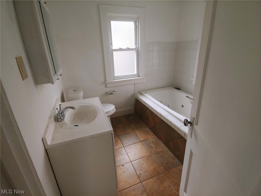 1464 Sherbrook Road Cleveland, OH 44121 - Photo 9 of 15 Bathroom featuring tile floors, vanity, toilet, and tiled tub