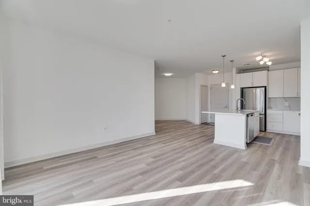 a view of kitchen with kitchen island wooden floor center island and stainless steel appliances