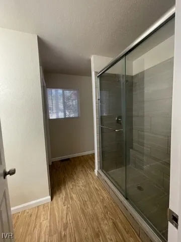 a bathroom with a shower and a wooden floor