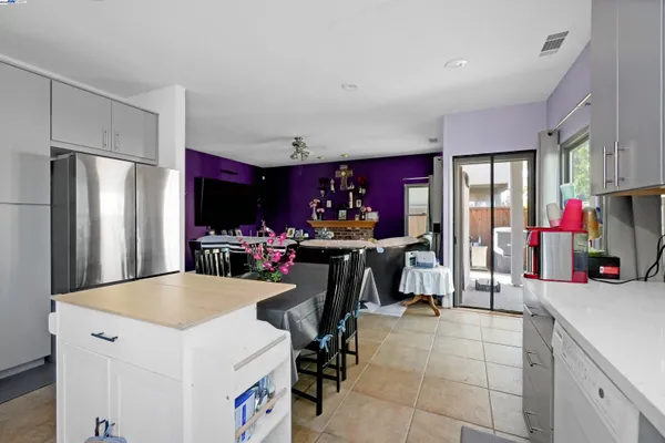 a kitchen with kitchen island granite countertop a table chairs microwave and cabinets