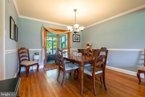 a view of a dining room with furniture a chandelier and wooden floor