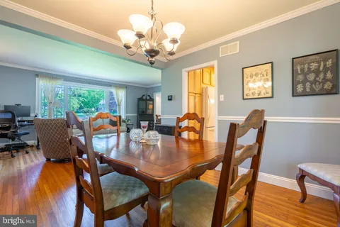 a kitchen with kitchen island a stove a table and chairs in it
