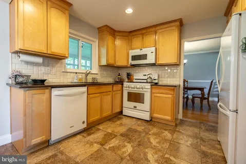 a kitchen with kitchen island granite countertop wooden cabinets a counter top space and stainless steel appliances