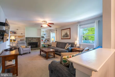a living room with furniture a chandelier and a flat screen tv