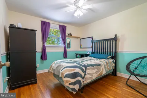 a bedroom with a bed a window and potted plant