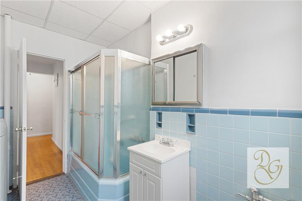 9801 Shore Road, Unit 2O Brooklyn, NY 11209 - Photo 12 of 24 a bathroom with a sink a toilet and shower