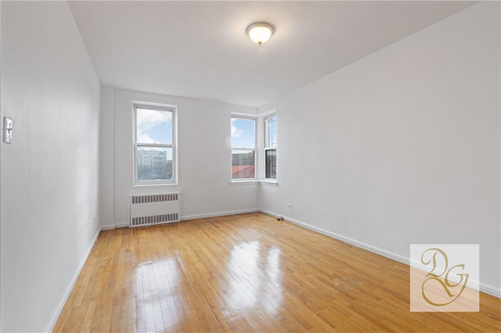 9801 Shore Road, Unit 2O Brooklyn, NY 11209 - Photo 9 of 24 an empty room with wooden floor and windows