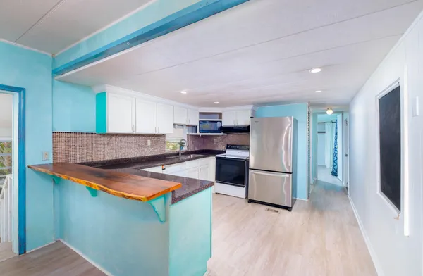 a kitchen with granite countertop a sink stove and refrigerator