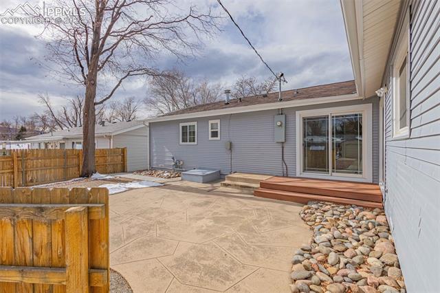 2125 Winston Road Colorado Springs, CO 80909 - Photo 20 of 37 Rear view of house featuring a deck and a patio area