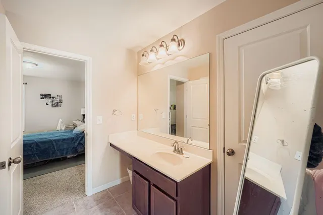 a bathroom with a double vanity sink a mirror and a bathtub