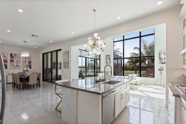 a kitchen with kitchen island granite countertop a table and a chandelier
