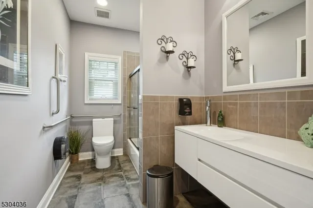 a bathroom with a sink toilet and window