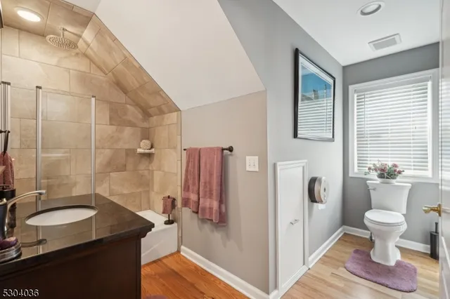 a bathroom with a granite countertop sink toilet and shower