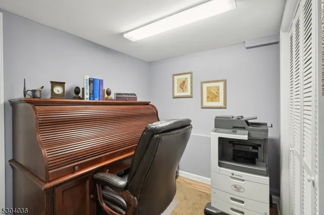 a view of a workspace with furniture and a window