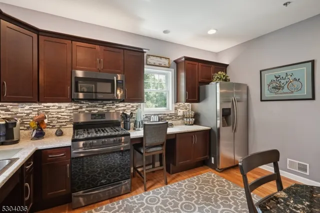 a kitchen with stainless steel appliances granite countertop a refrigerator stove and microwave