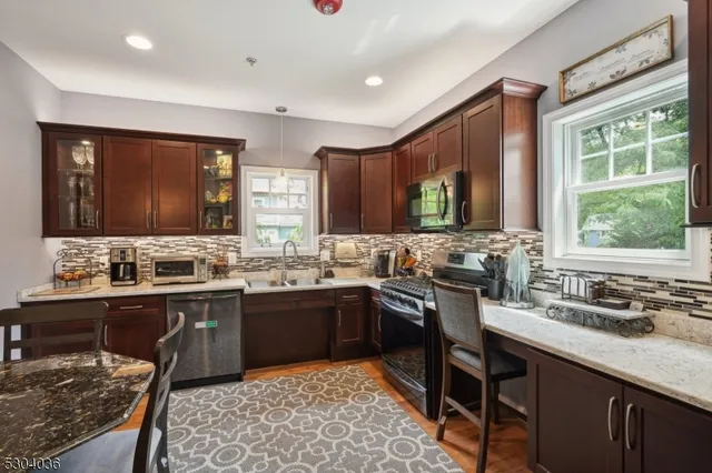 a kitchen with lots of counter top space sink and stainless steel appliances