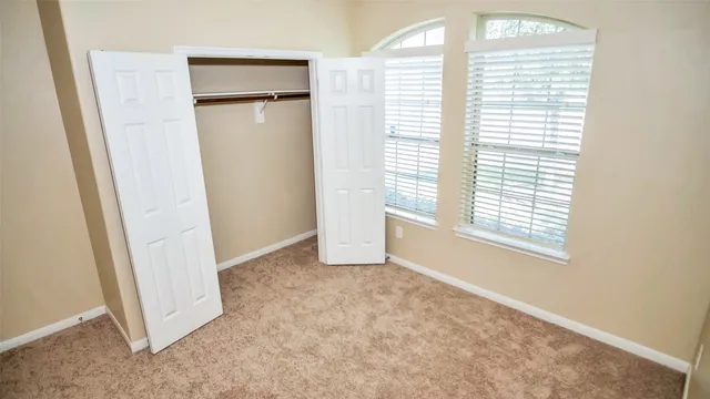 an empty room with windows and closet