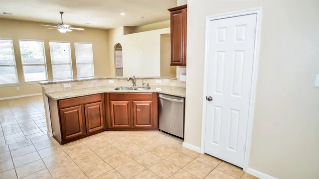 a spacious bathroom with a granite countertop sink a mirror and a bathtub