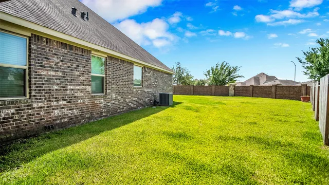 a view of a house with a yard and large tree