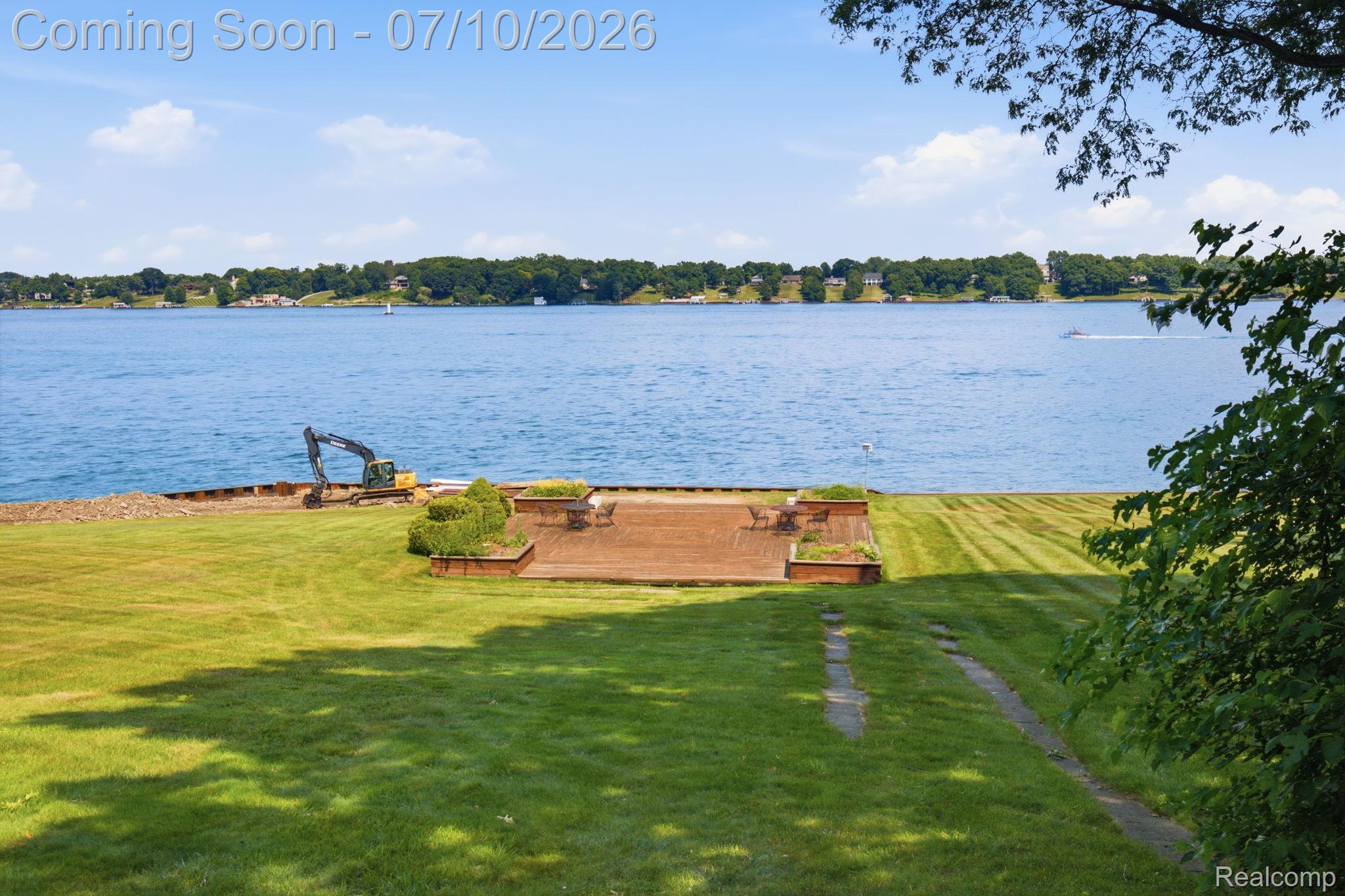 1501 River Road, Unit 301 St. Clair, MI 48079 - Photo 32 of 32 Expansive waterfront lawn featuring a terraced patio with integrated planters, offering direct access to the lake