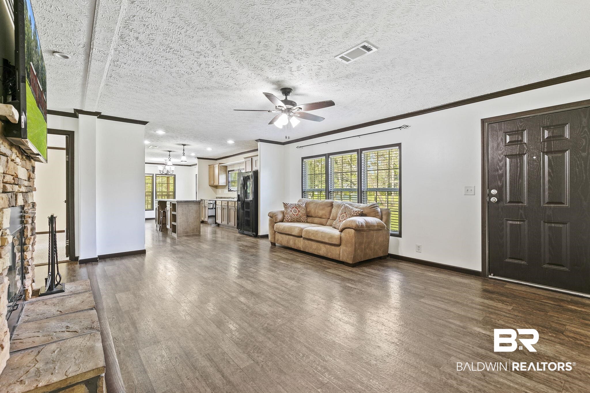 35641 County Road 39 Stapleton, AL 36578 - Photo 11 of 46 Unfurnished living room with a textured ceiling, a fireplace, dark hardwood / wood-style flooring, and ceiling fan