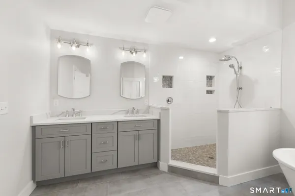 a bathroom with a double vanity sink mirror and toilet
