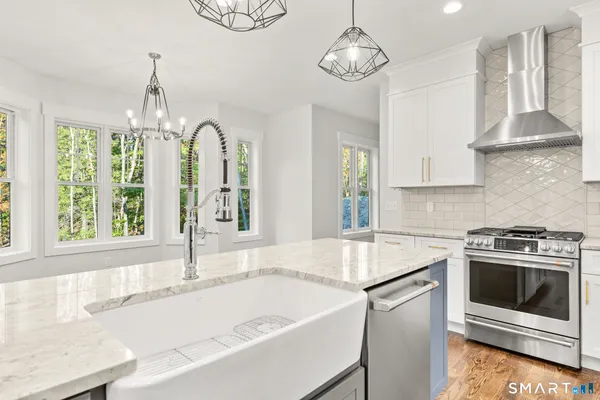 a kitchen with stainless steel appliances granite countertop a stove a sink and a refrigerator